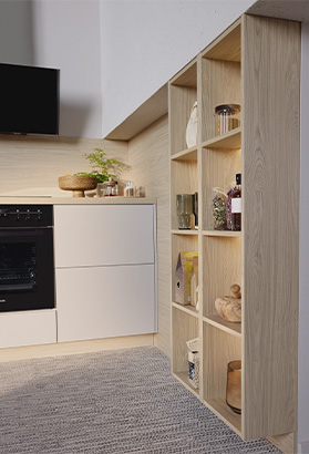 Rangement vertical en bois avec étagères ouvertes, rempli de bocaux, ustensiles et accessoires, situé dans une cuisine lumineuse et contemporaine